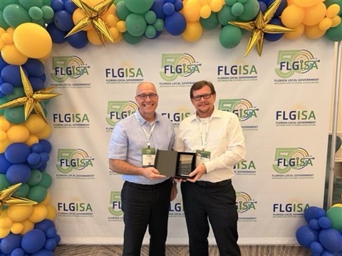 Photo shows Stanley Fidge, Information Security Officer, and Bill Jones, Chief Information Officer, accept the award from FLGISA.