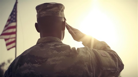 soldier salutes the sky as the sun sets